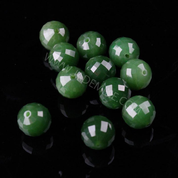 Cluster of green 12mm faceted beads with drill holes on black background