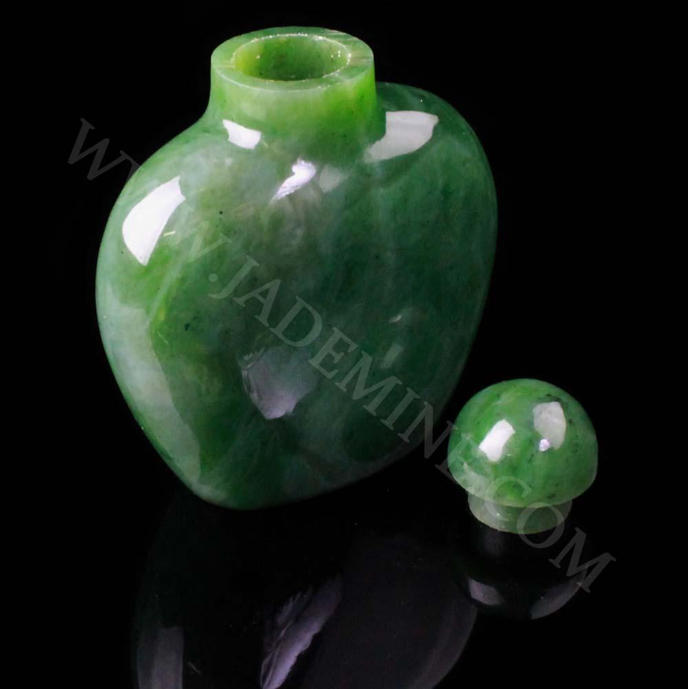Green jade perfume bottle with open neck and a separate spherical cap resting to the side.