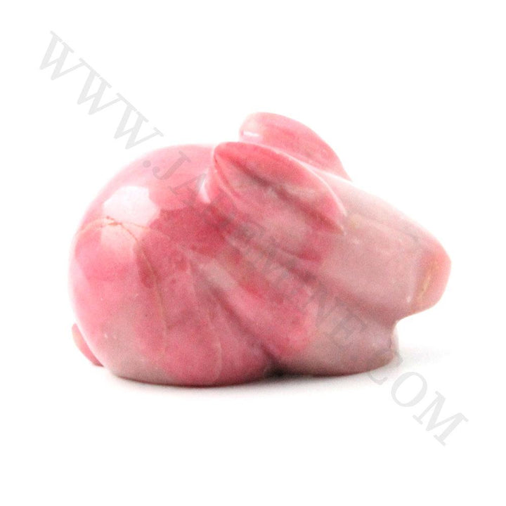 Pink rhodonite rabbit figurine viewed from the side against a white background