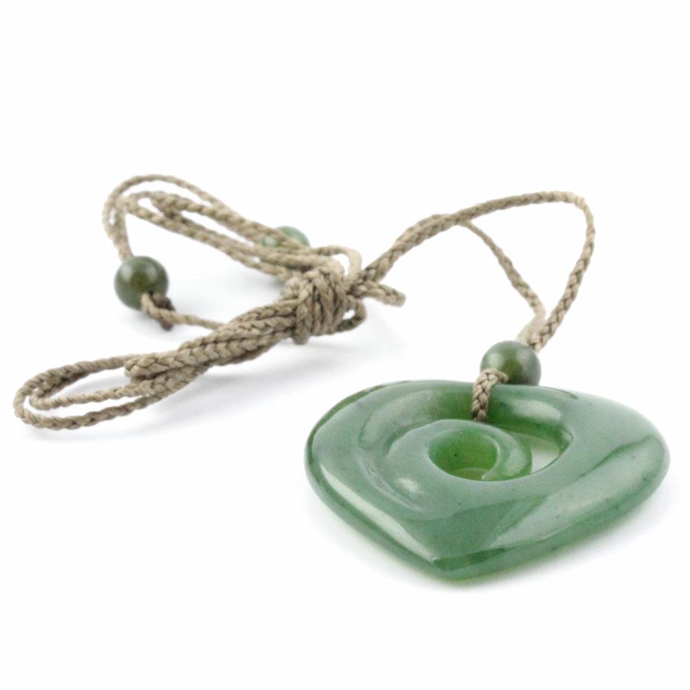 Close-up of jade koru heart pendant on a braided cord with beads
