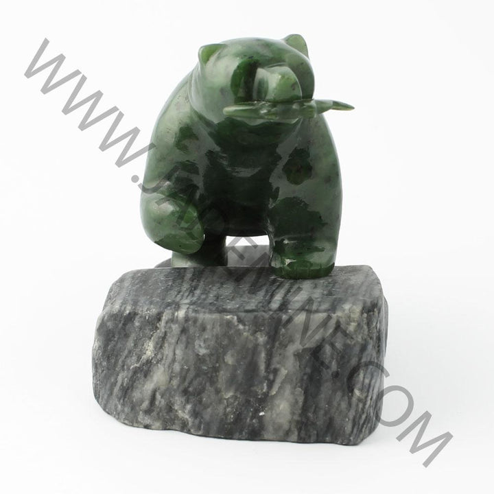 Green bear statue perched on a dark granite base.