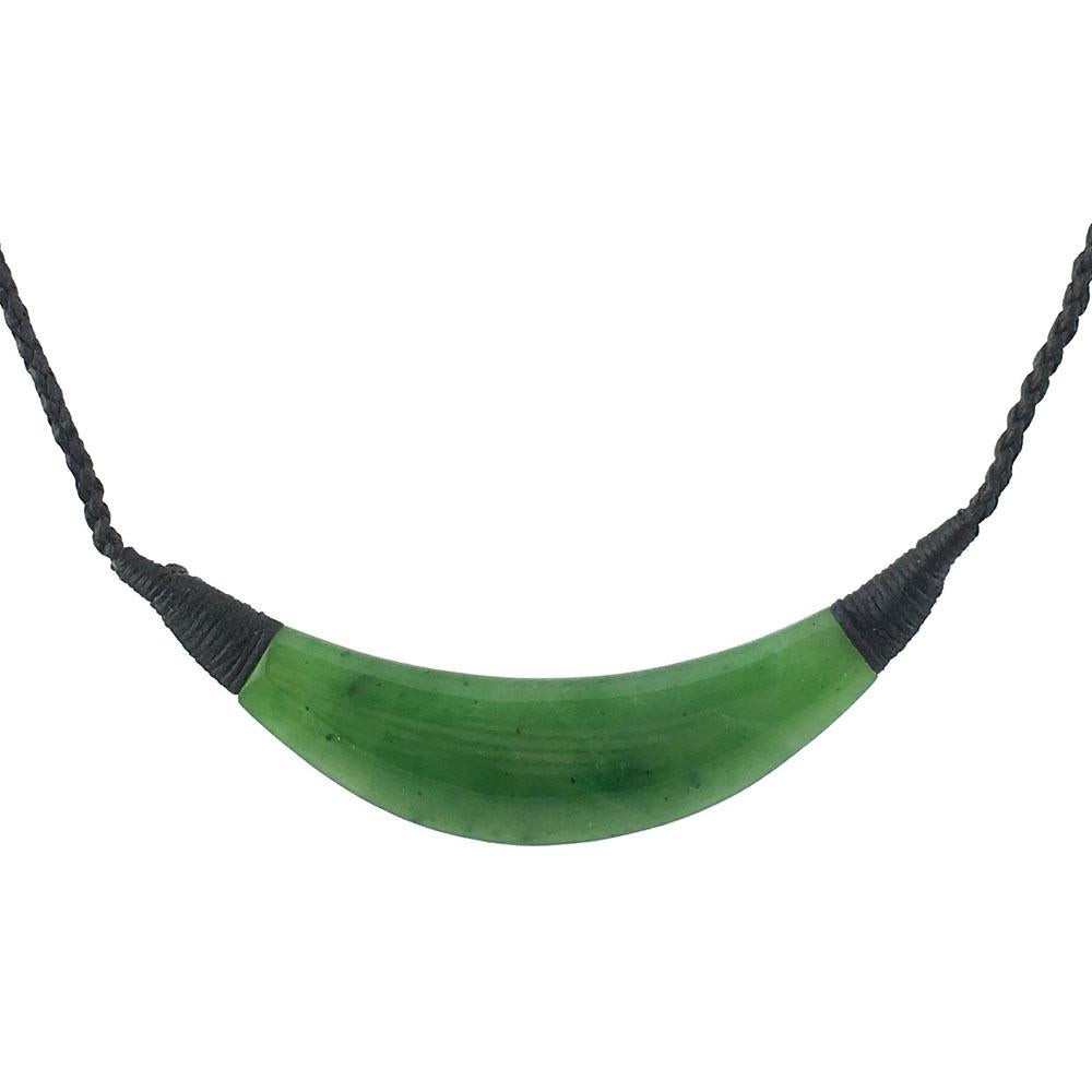 Green jade pendant, with wrapped black cord on a white background