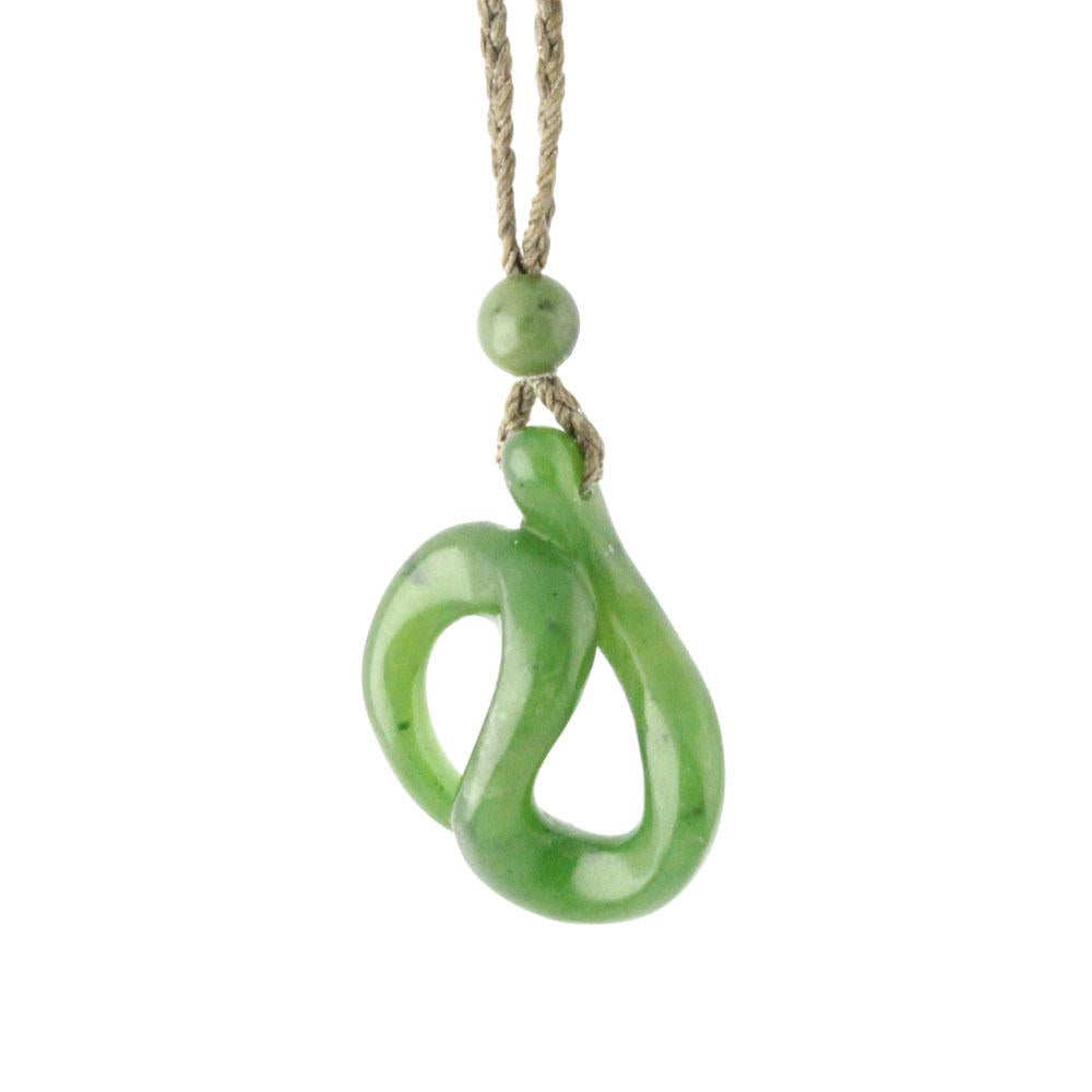 Green jade pendant on a knotted natural cord with two round beads.