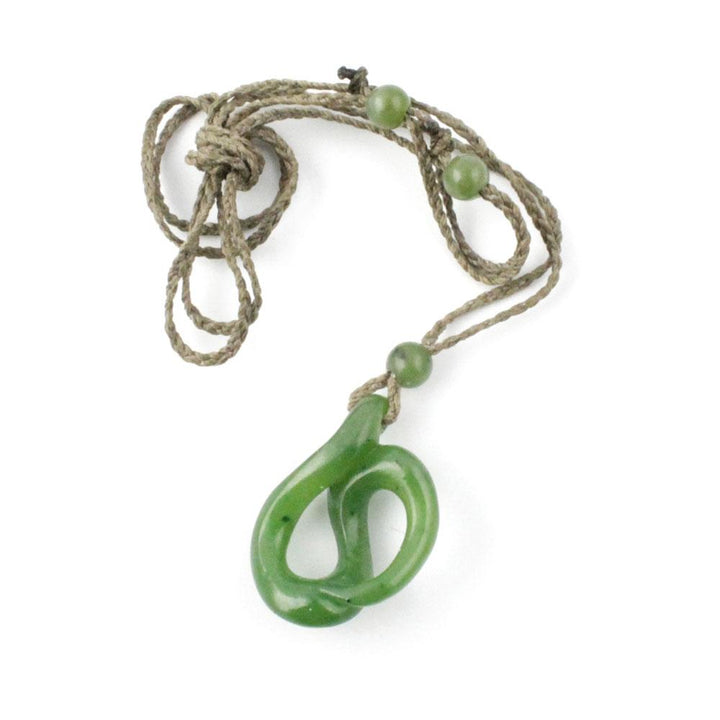 Green jade pendant on a knotted beige cord with green bead accents