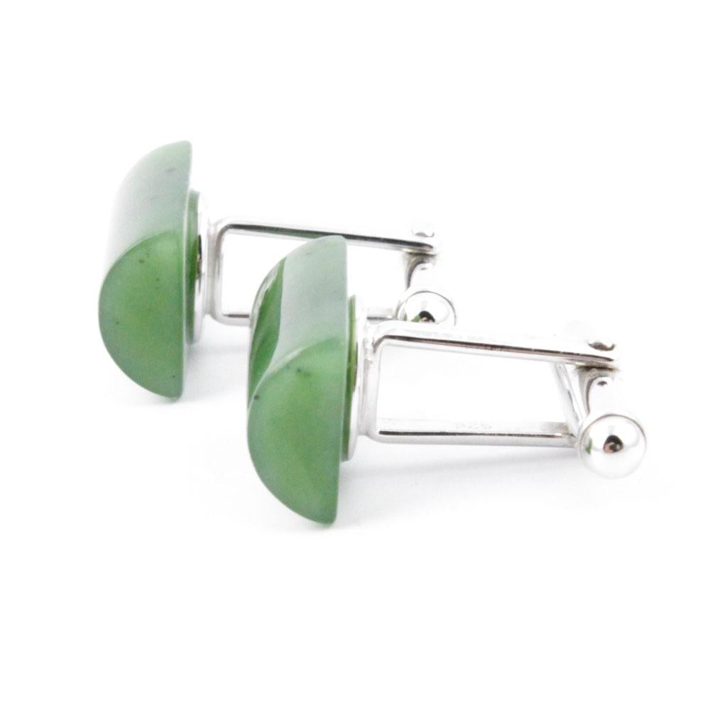 Close up of jade cufflinks with green rectangular stones set in silver frames.