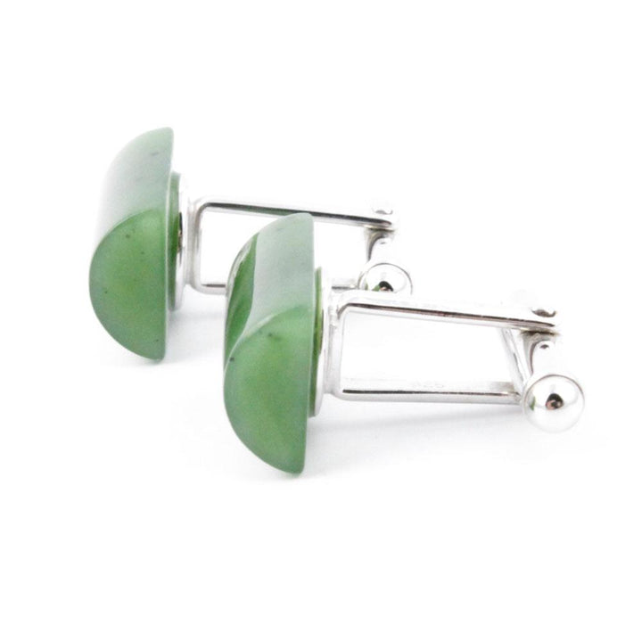 Close up of jade cufflinks with green rectangular stones set in silver frames.