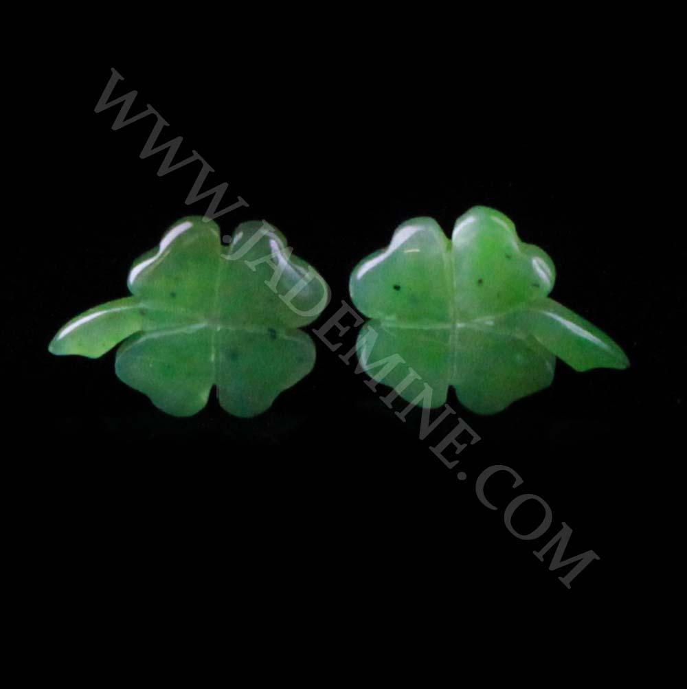 Green Canadian nephrite jade shamrock earrings on a black background.