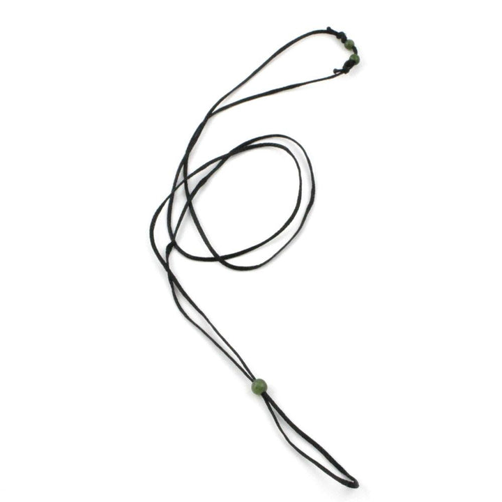 Waxed black cord necklace featuring a green jade bead at the end and small green beads at the top.