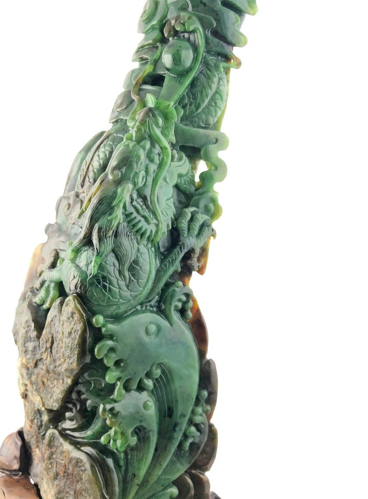 Close view of a green jade dragon entwined with rocks showing detailed scales and flowing form