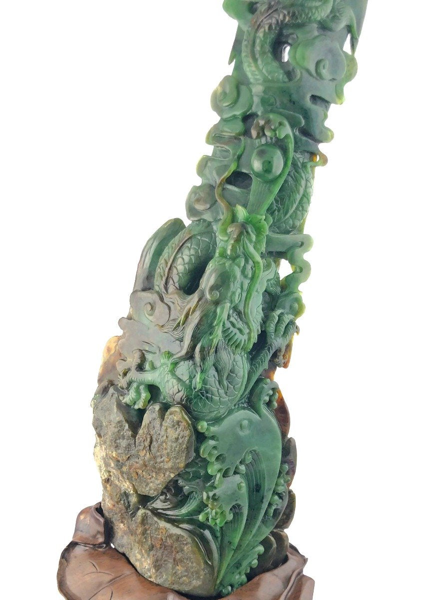 Jade dragon statue wrapped around a rocky column on a carved wooden pedestal