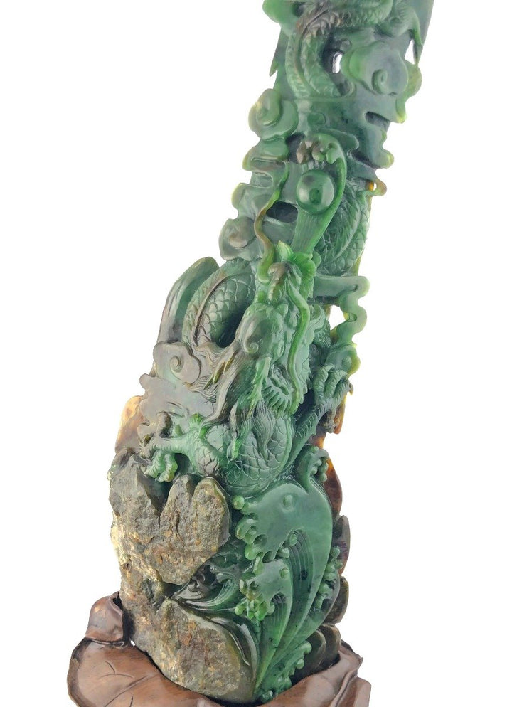 Jade dragon statue wrapped around a rocky column on a carved wooden pedestal