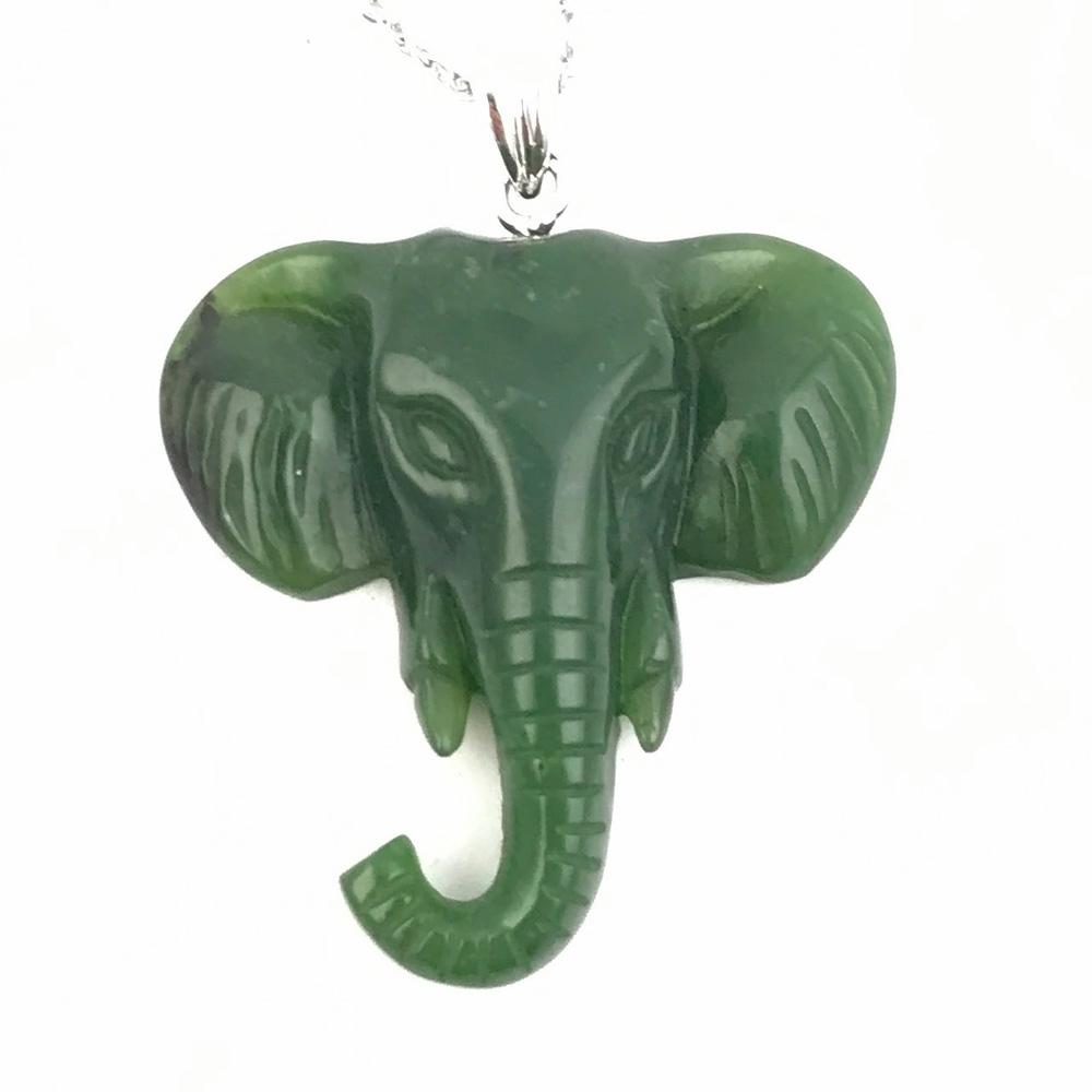 Green jade elephant pendant with carved features and curling trunk on a silver chain