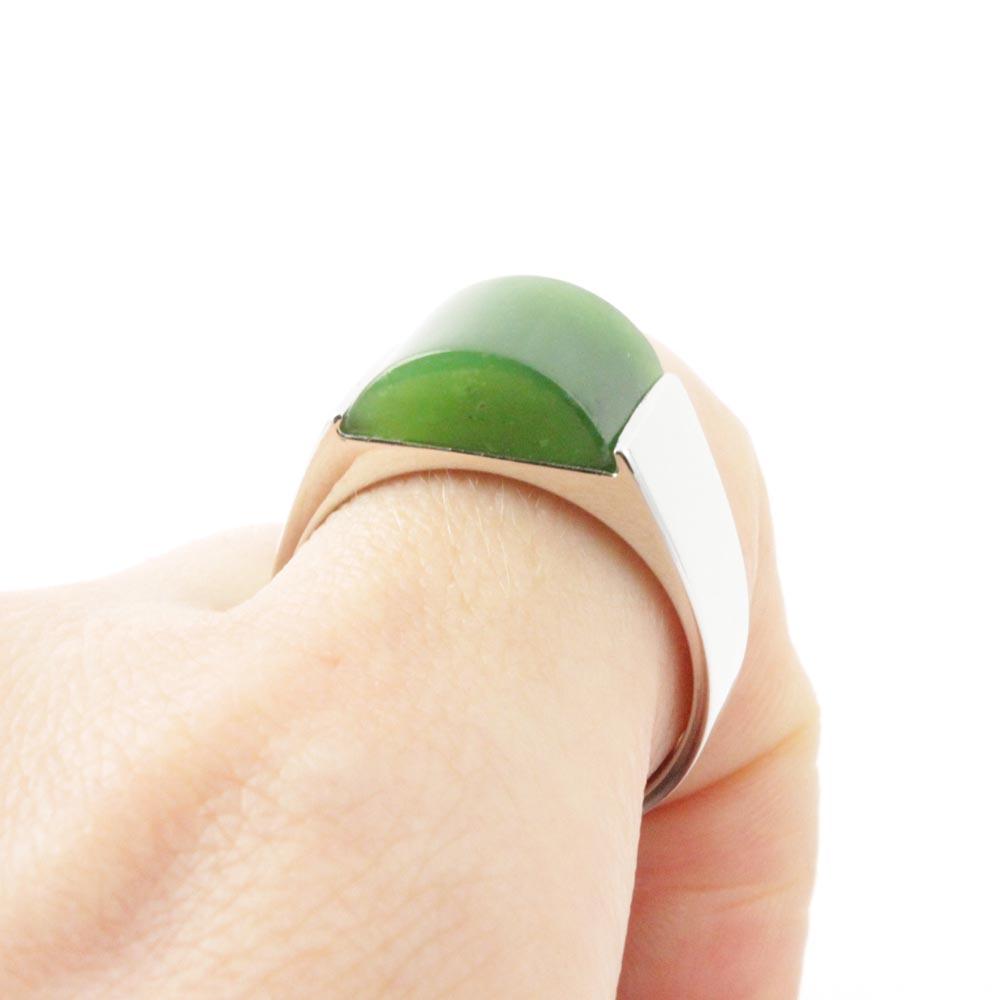 Close-up of Jade Ring 0364 on finger featuring a green domed jade stone set in a silver band
