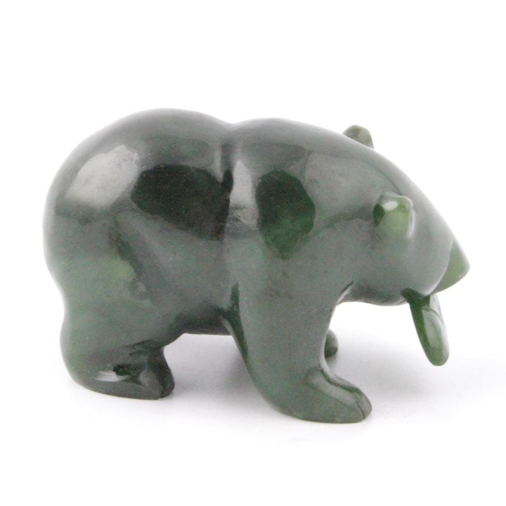 Dark green bear figurine with a fish in its mouth