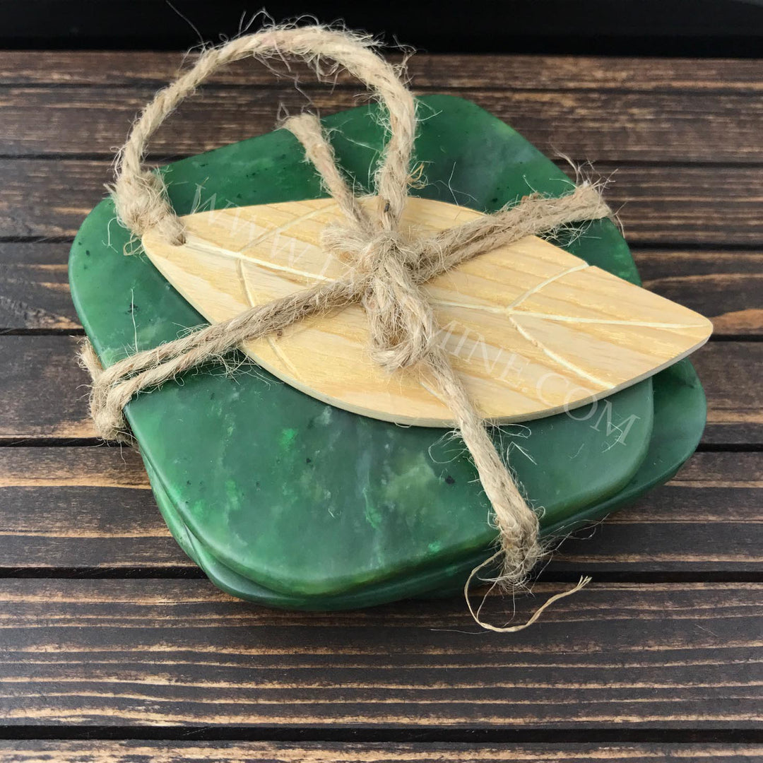 Green jade coasters tied with rustic twine and a wooden leaf shaped accent on top