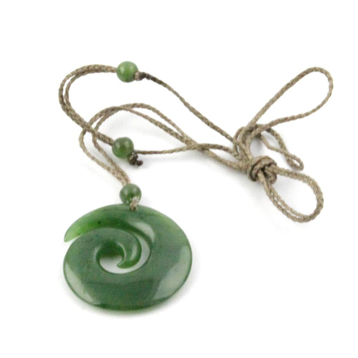 Green jade koru pendant with spiral design on beige cord accented by green beads