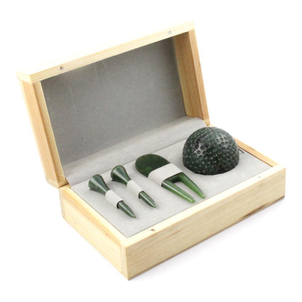 Open wooden box showing a green golf ball and three green tees inside