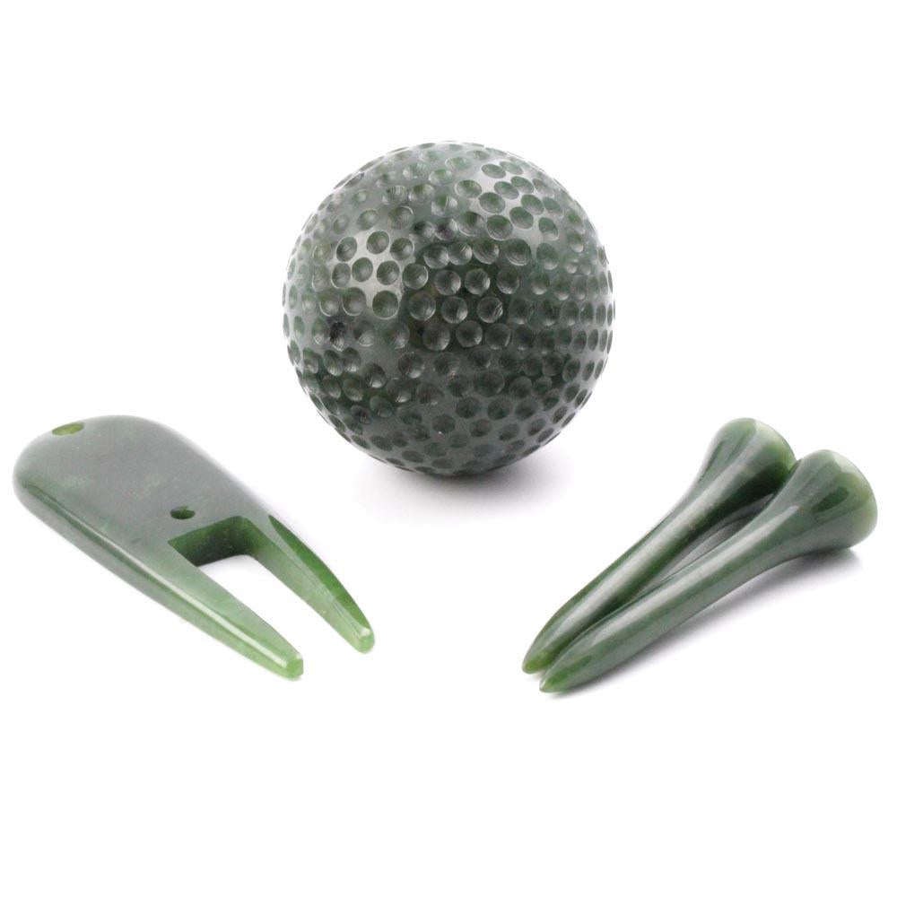 Green golf ball with two tees and a two-prong golf accessory on a white background