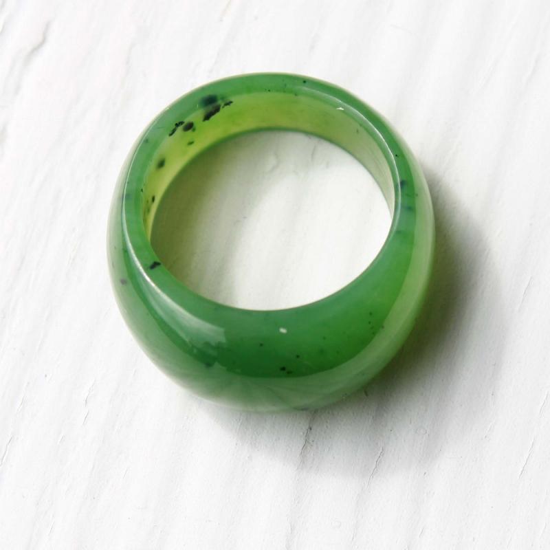 Close up of green jade dome top ring showing a glossy surface and subtle internal specks