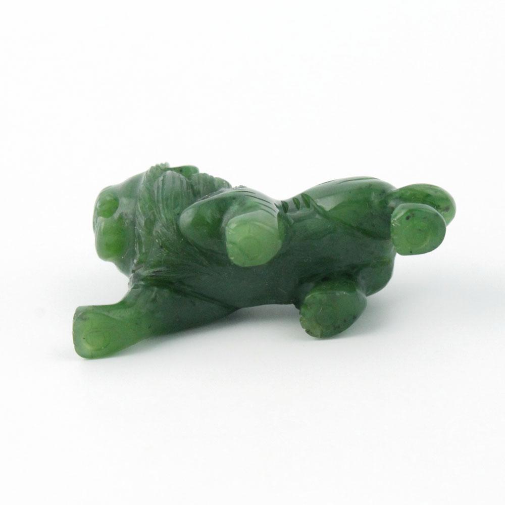 Green stone lion figurine lying on its side