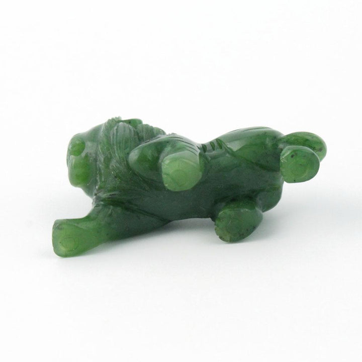 Green stone lion figurine lying on its side
