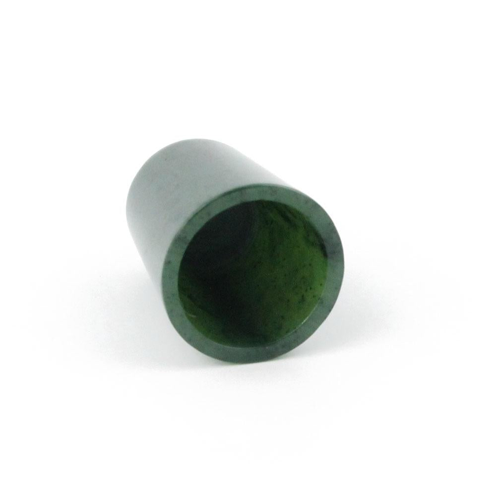 Green hollow thimble on its side showing the open end