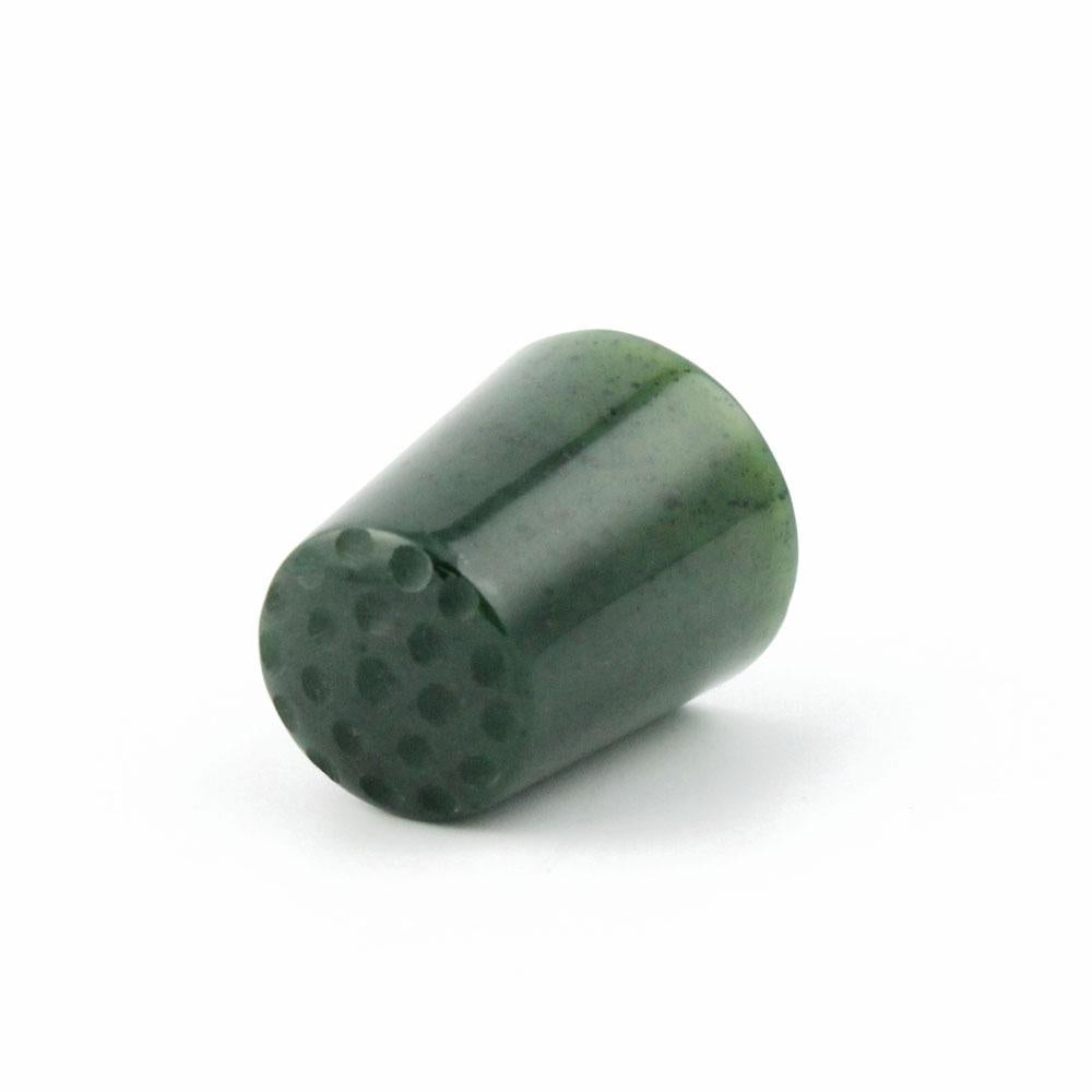 Dark green cylindrical thimble with a perforated dotted bottom viewed from the side