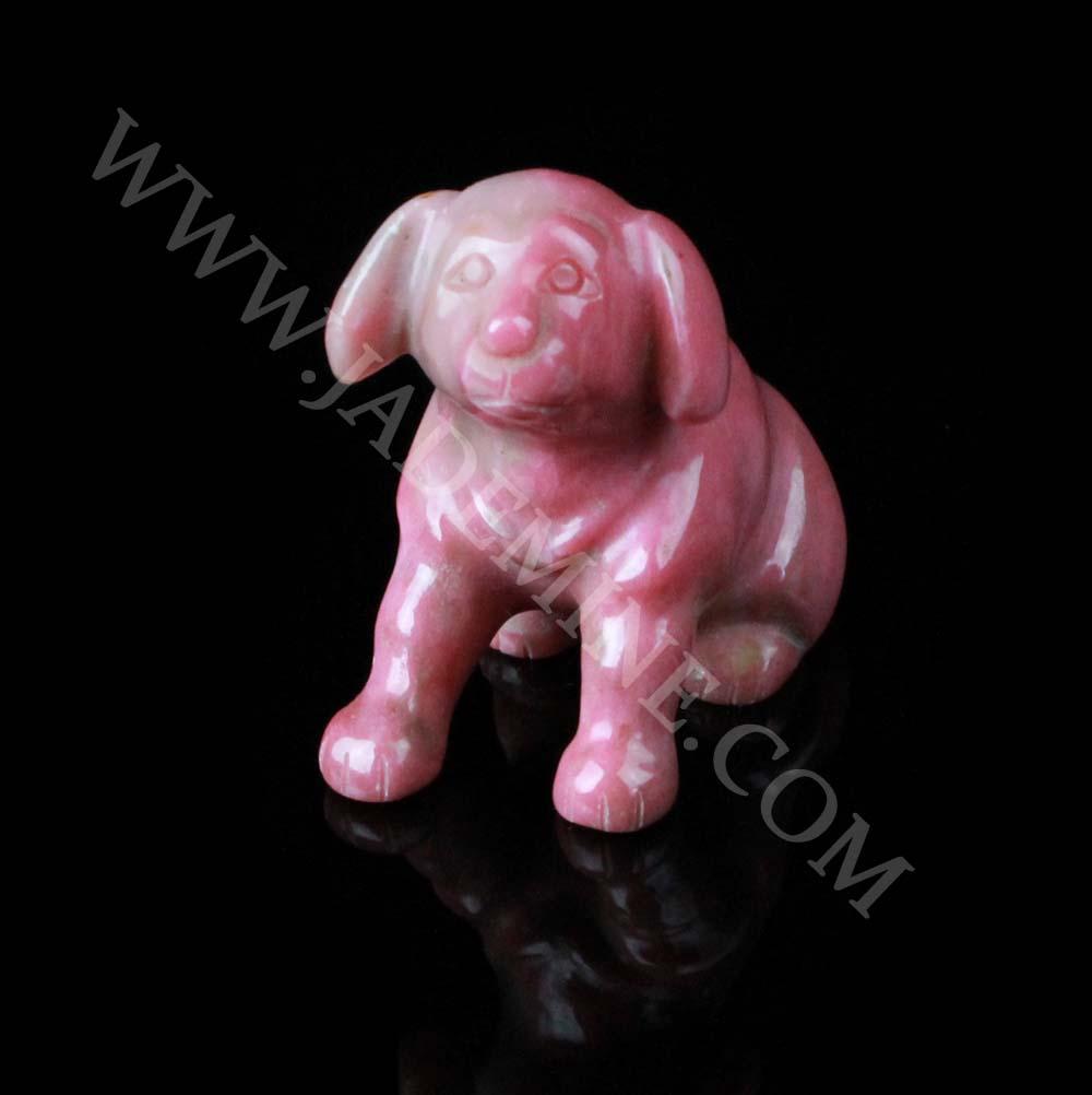 Polished pink rhodonite Labrador retriever figurine on a black background
