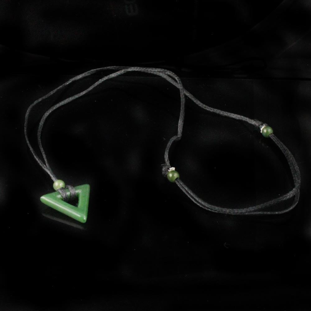 Front view of jade triangle pendant on black cord with a green bead against a dark background.