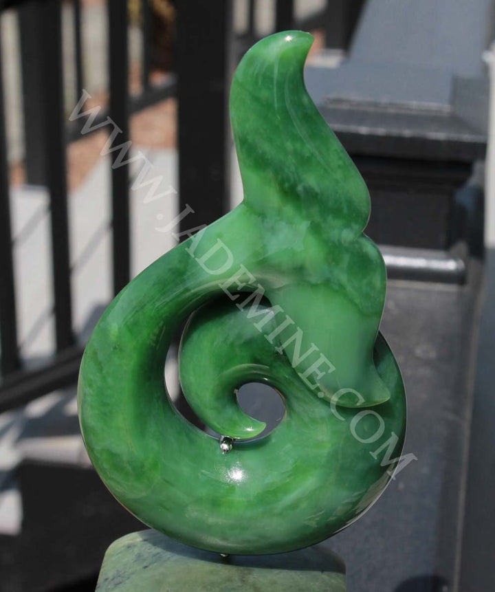 Front angle of Jade Whale Tail on Jade Base sculpture with vivid green marbling and circular swirl.