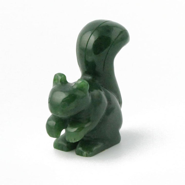 Dark green 1.5 inch squirrel figurine seen from a three quarter angle with a rounded head and curved tail