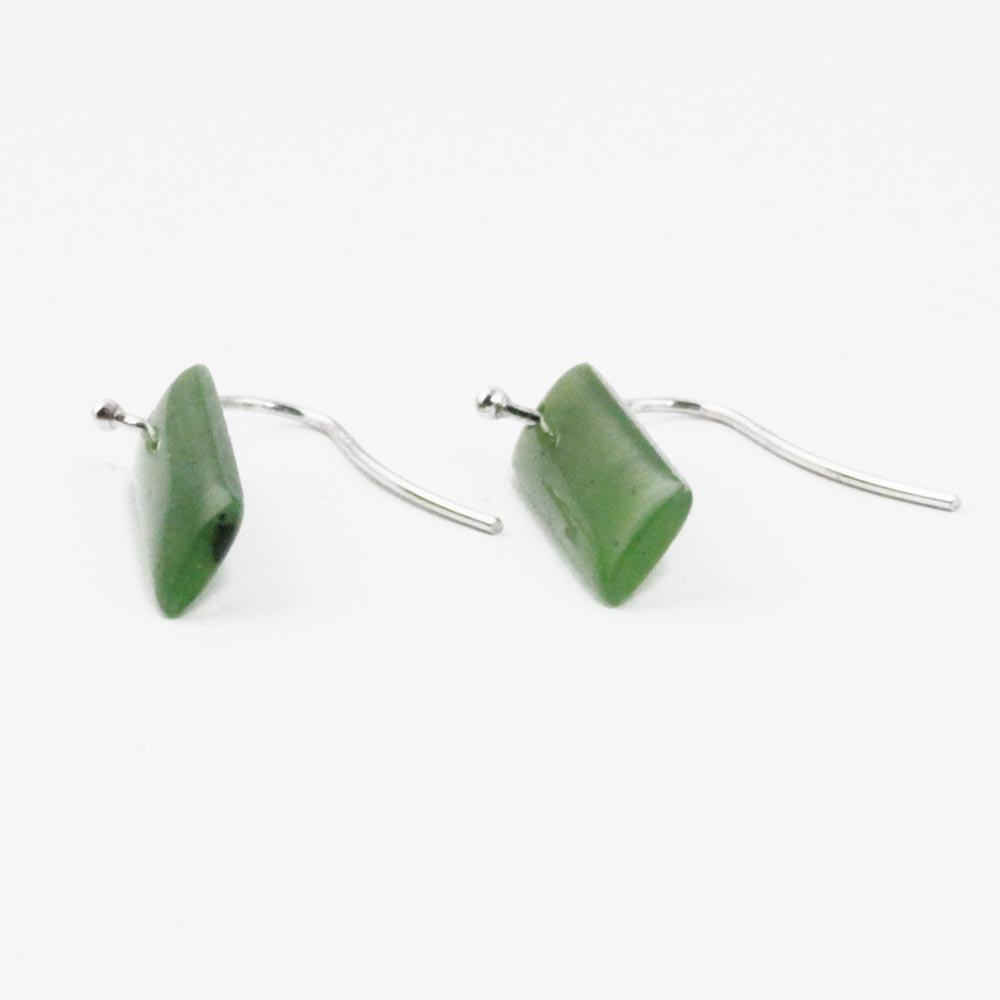 Two rectangular green jade drop earrings with silver hooks on a white background