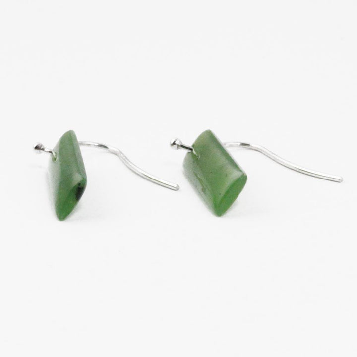Two rectangular green jade drop earrings with silver hooks on a white background