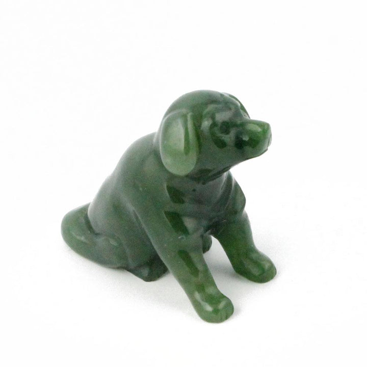 Small green Labrador retriever figurine sitting on a white surface.
