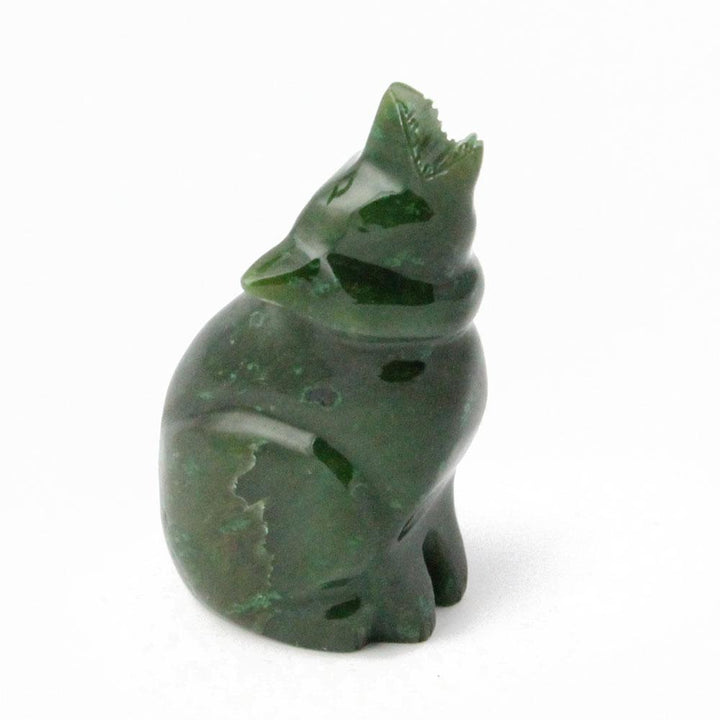 Dark green carved wolf figurine with jagged ears on white background