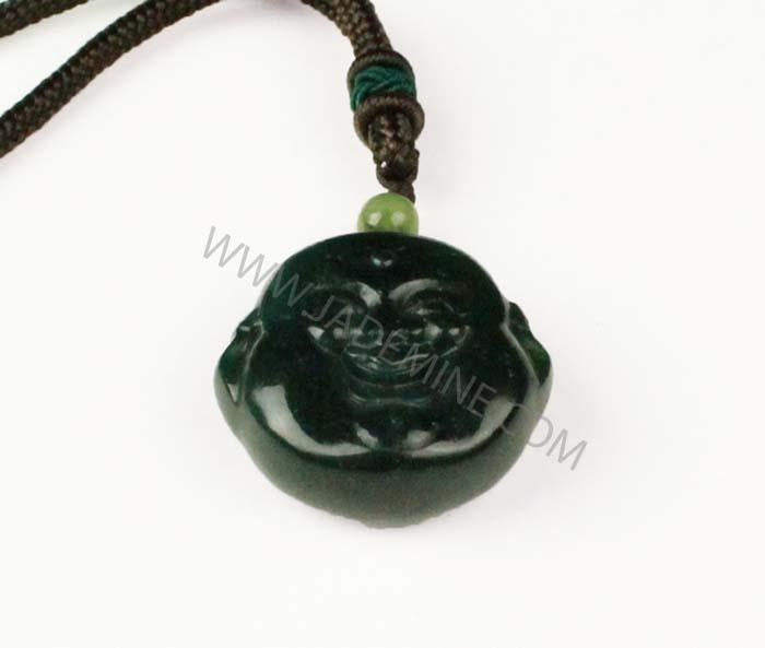 Dark green carved Buddha head pendant on a brown cord with a small green bead above on a white background