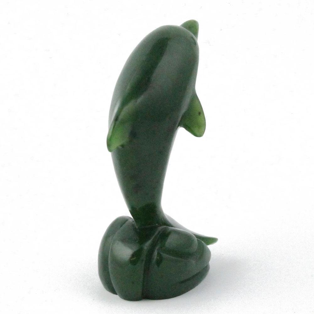 Green dolphin figurine viewed from the side with tall curved body on a rounded base