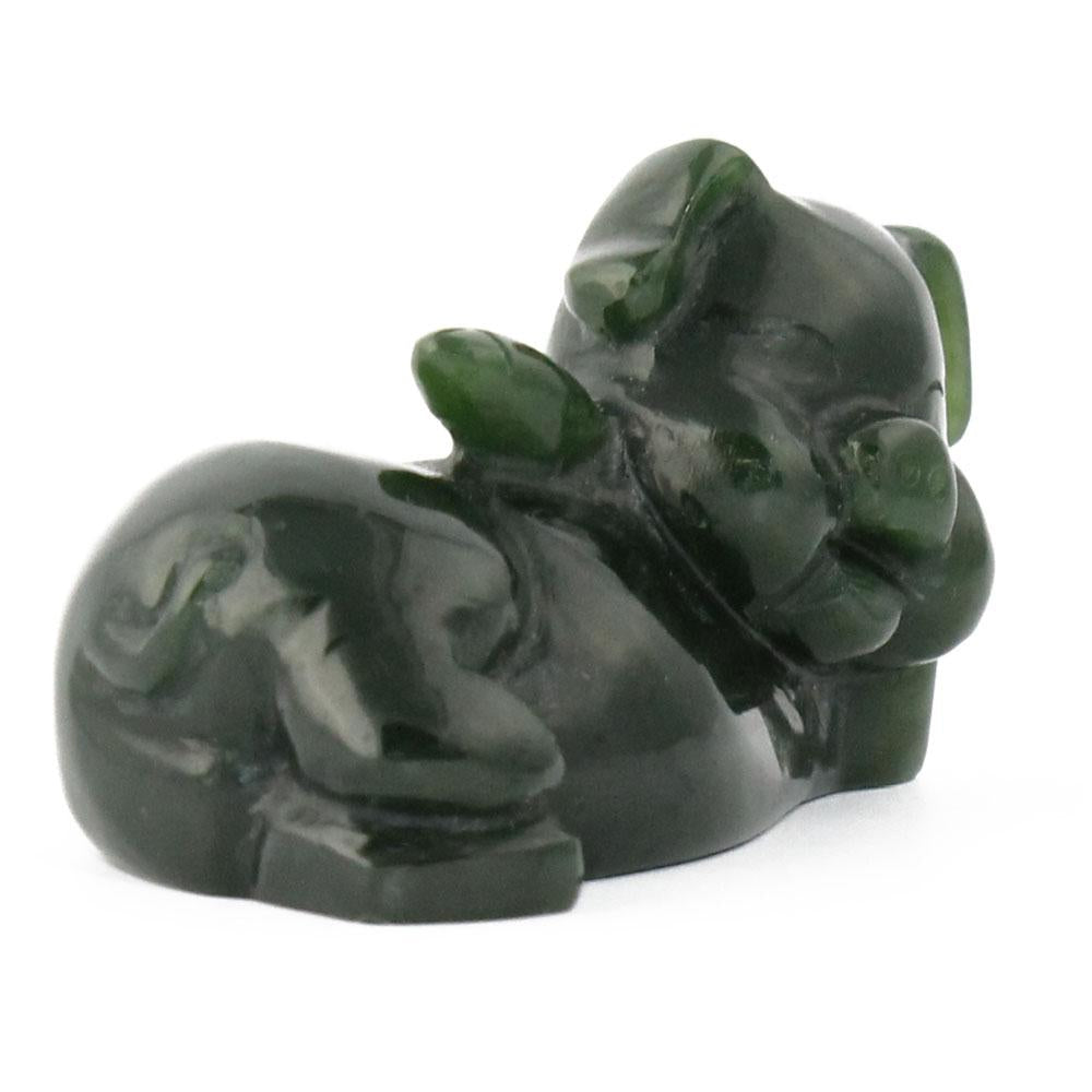 Dark green glossy pig figurine lying down