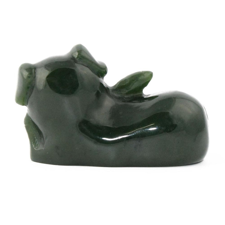 Dark green glossy pig figurine seen in a side view in a reclining pose