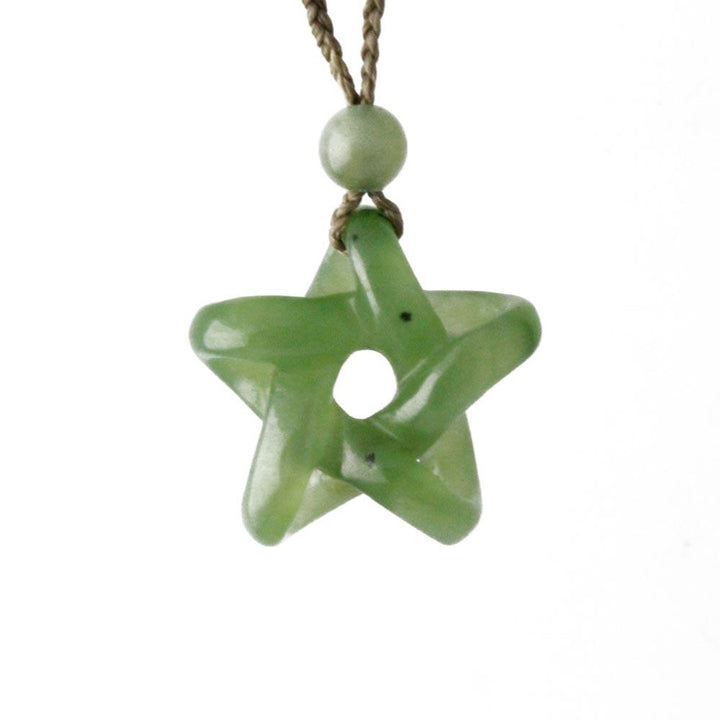 Jade star pendant with a central hole hanging from a brown cord with a small round jade bead above.