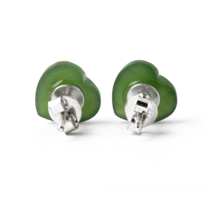 Two green jade heart stud earrings shown from a side angle with posts visible
