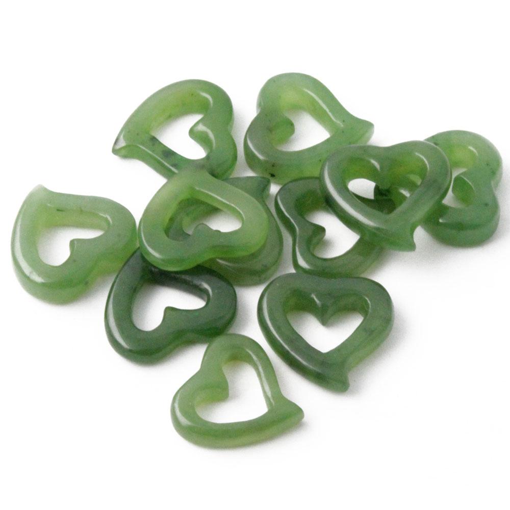 Green translucent heart shaped charms scattered on a white background
