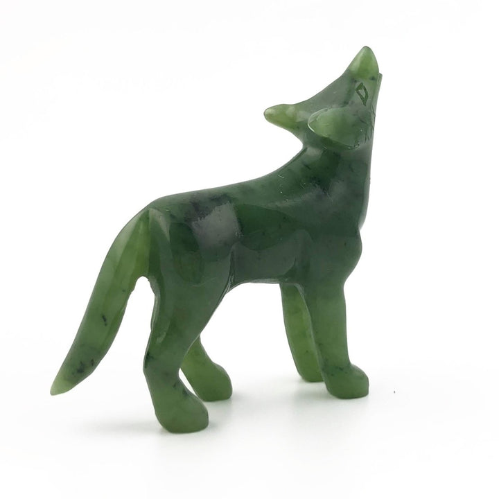 Green carved coyote figurine in a three quarter view highlighting its form.
