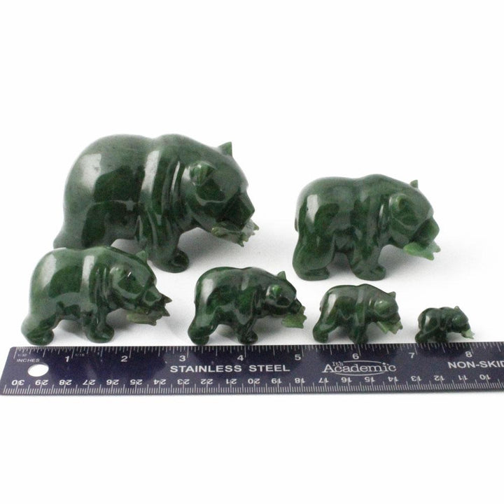 Group of green bear figurines in different sizes with a ruler for scale