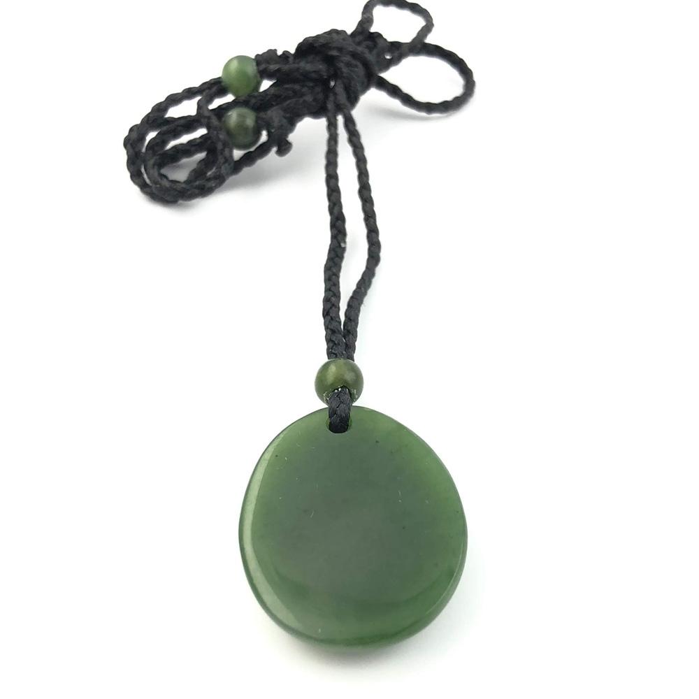 Green jade pendant on a black braided cord with a bead at the top