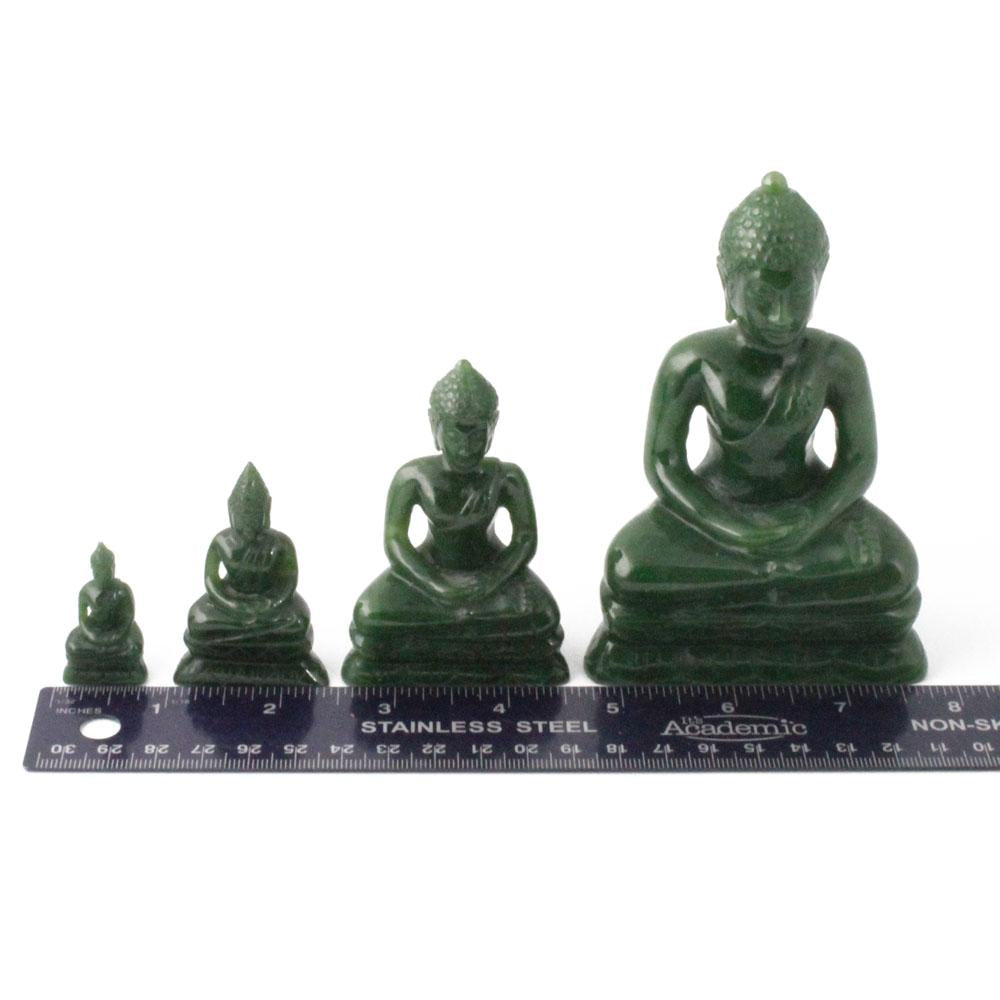 Thai green Buddha statues in four sizes arranged in a row with a stainless steel ruler