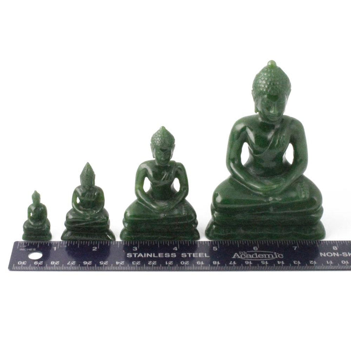 Thai green Buddha statues in four sizes arranged in a row with a stainless steel ruler