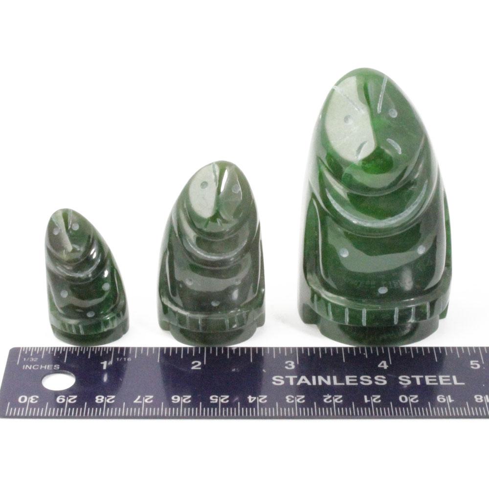 Three green Polar Jade spiral carved figures of varying heights beside a stainless steel ruler.