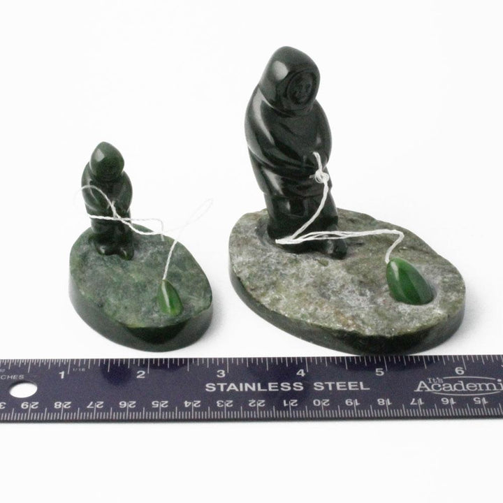 Two nephrite jade fisherman figures with strings and green beads on rock bases