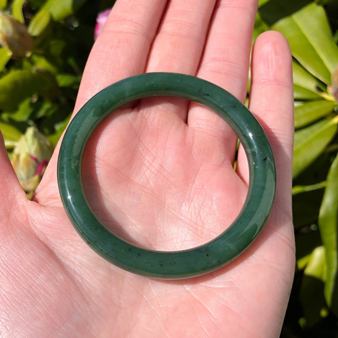 Green jade child size bangle 45mm held in a palm